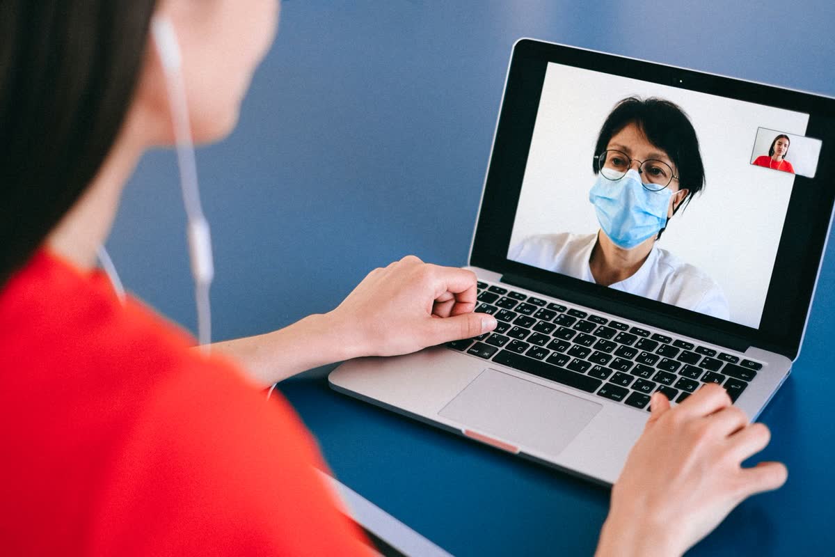 A patient at home talking to a doctor on a laptop