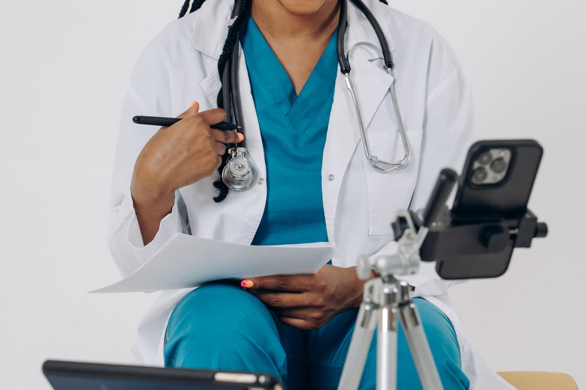 A clinician reviewing a request on a phone and taking notes